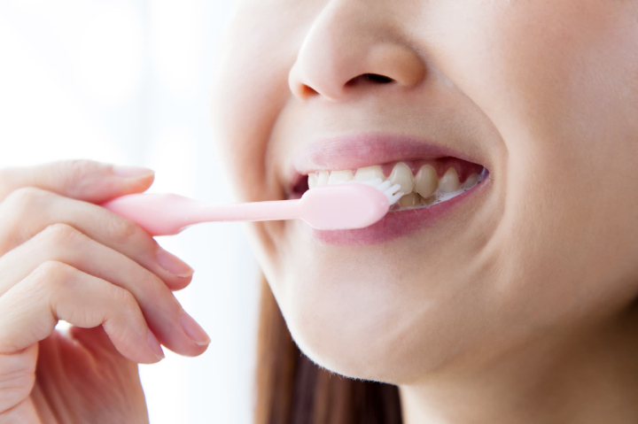 丁寧に歯磨きする女性の口元