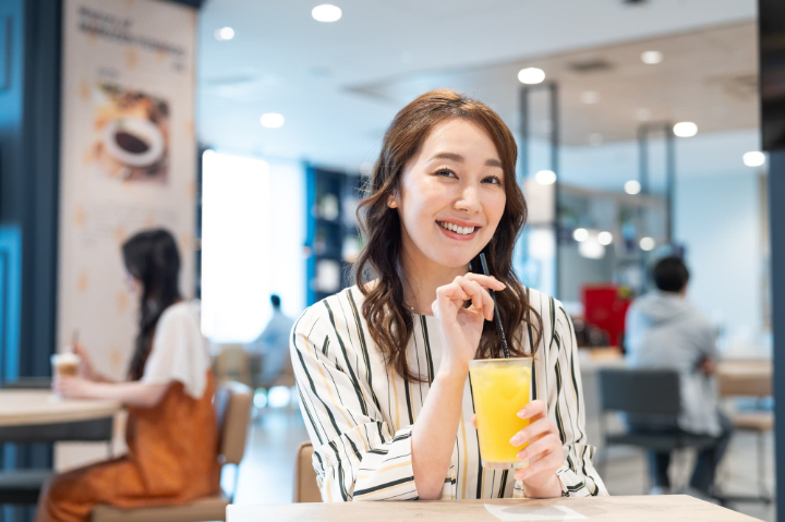 根管治療を終了して笑顔でジュースを飲む女性