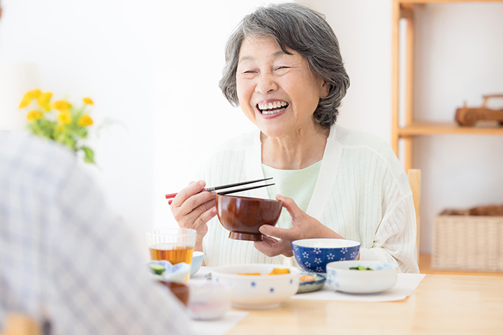 笑顔で食事を楽しむシニア女性