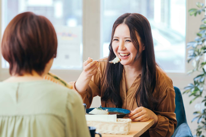 ドックベストセメントで虫歯を治療した女性が食事を楽しんでいるイメージ