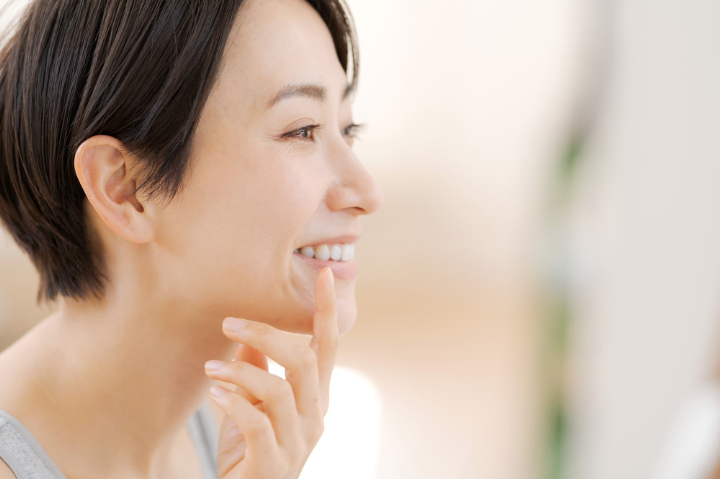 セラミックで治療した奥歯を鏡で確認する女性