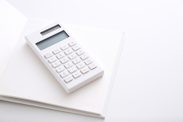 根管治療にかかる費用を計算するための電卓とノート