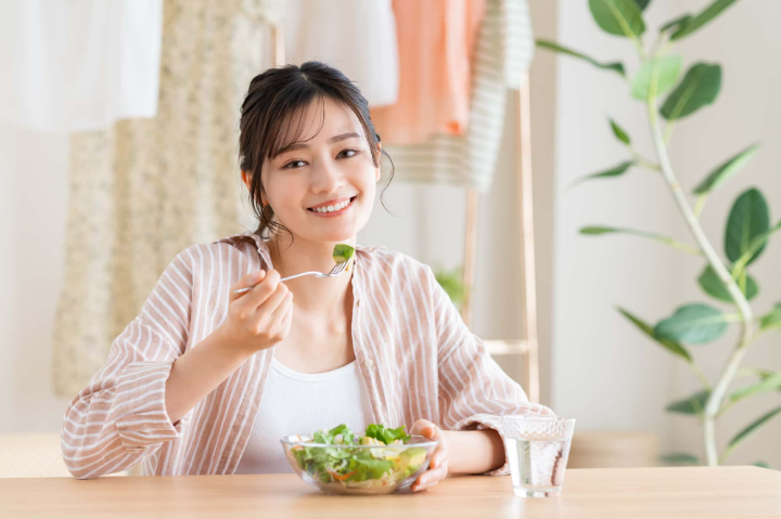 横向きに生えた親知らずを抜いて快適に食事をする女性