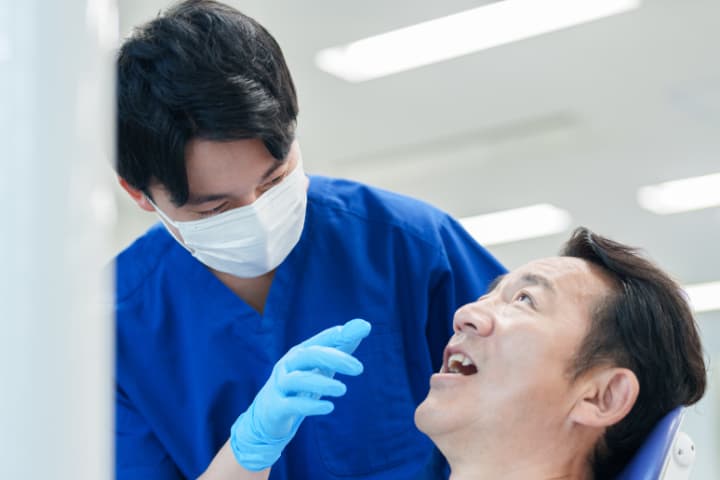 顎関節症の診断をする歯科医師