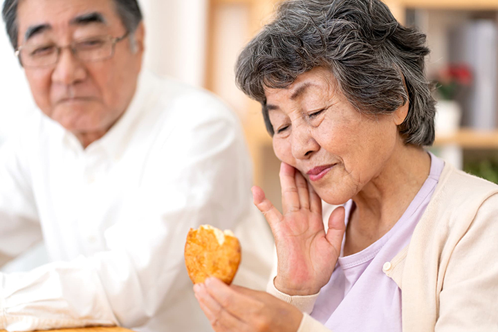 入れ歯が外れてうまく噛めない女性