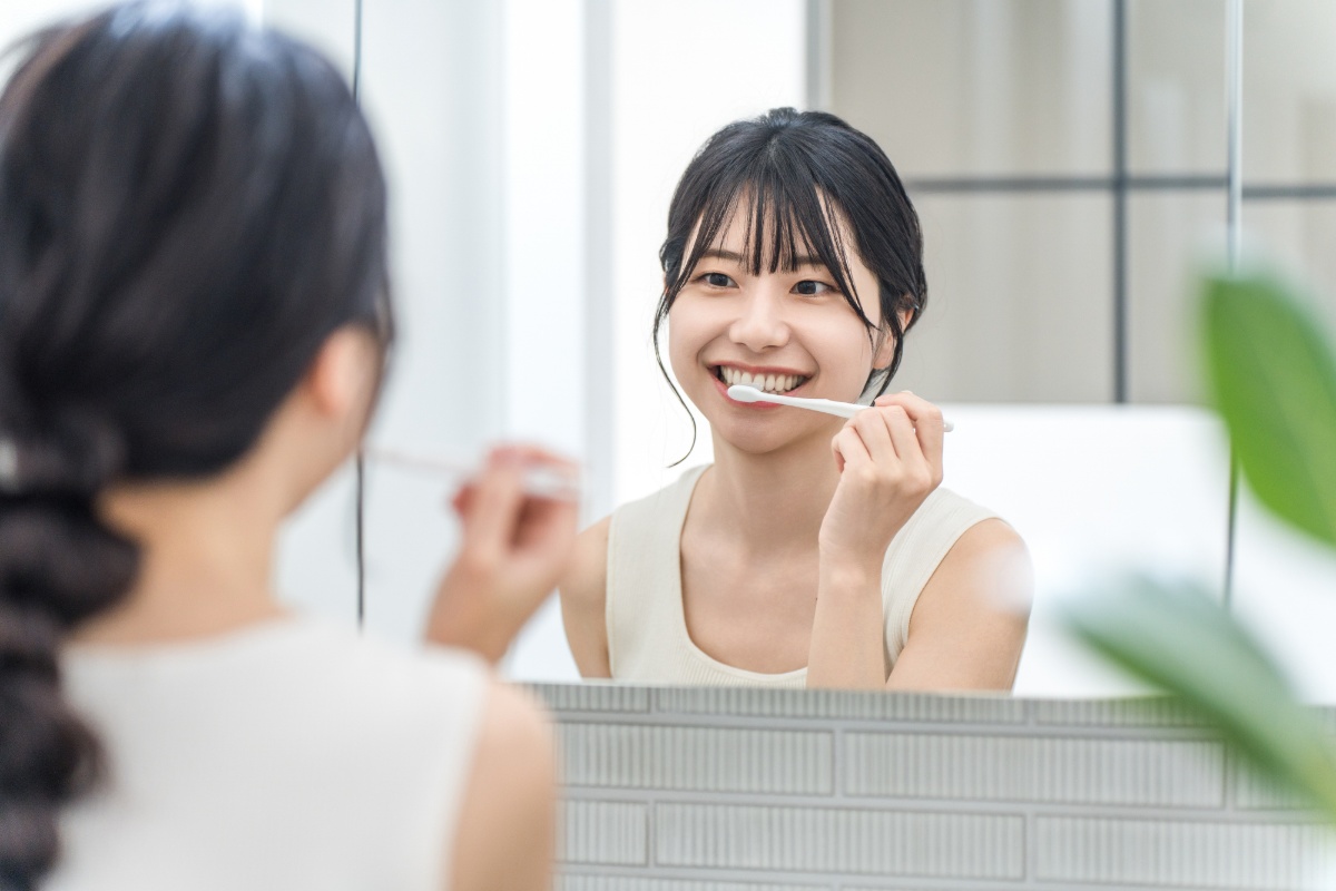 鏡を見ながらしっかり歯を磨く女性